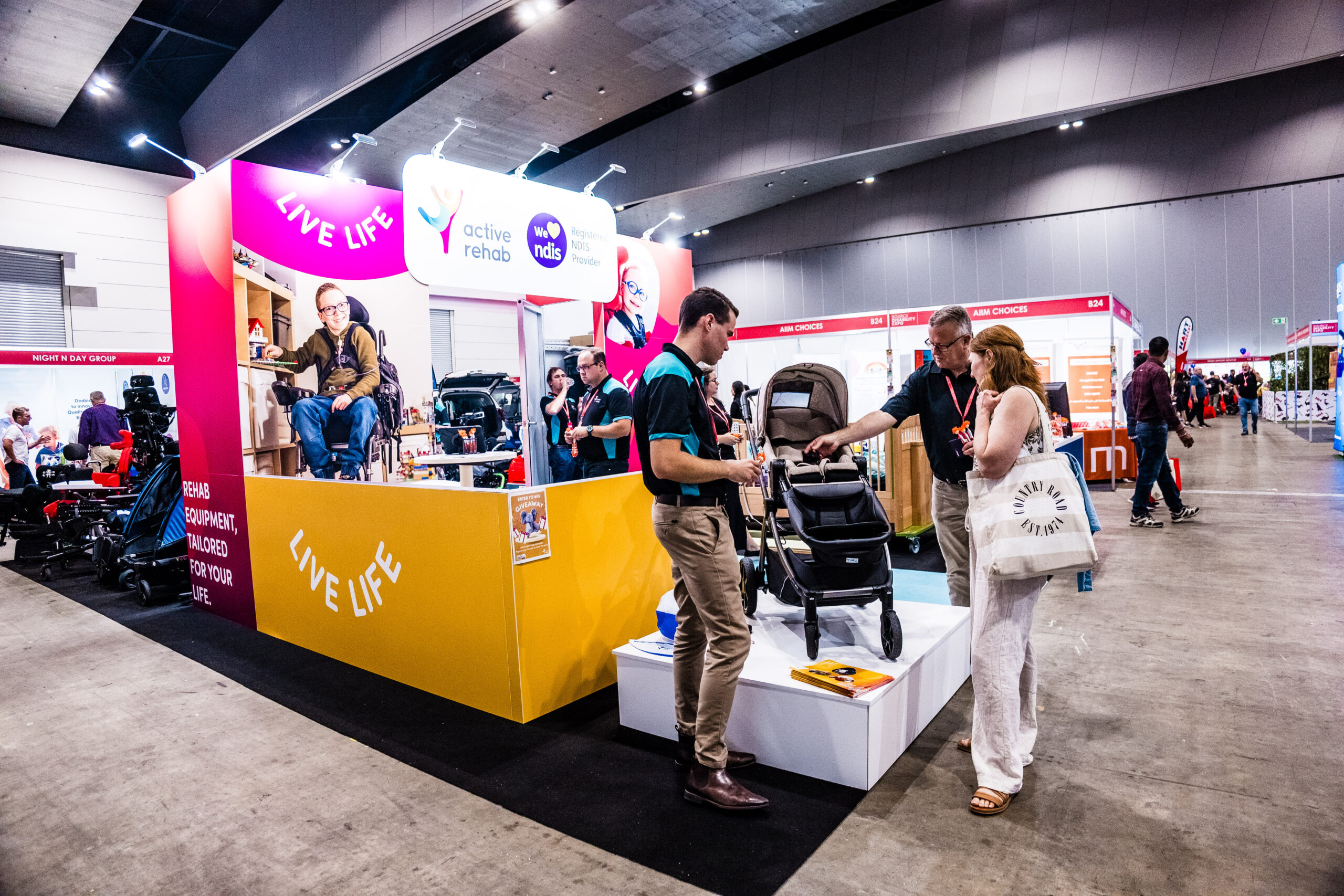 Active Rehab exhibition booth showcasing mobility equipment with staff assisting visitors at NDIS disability expo